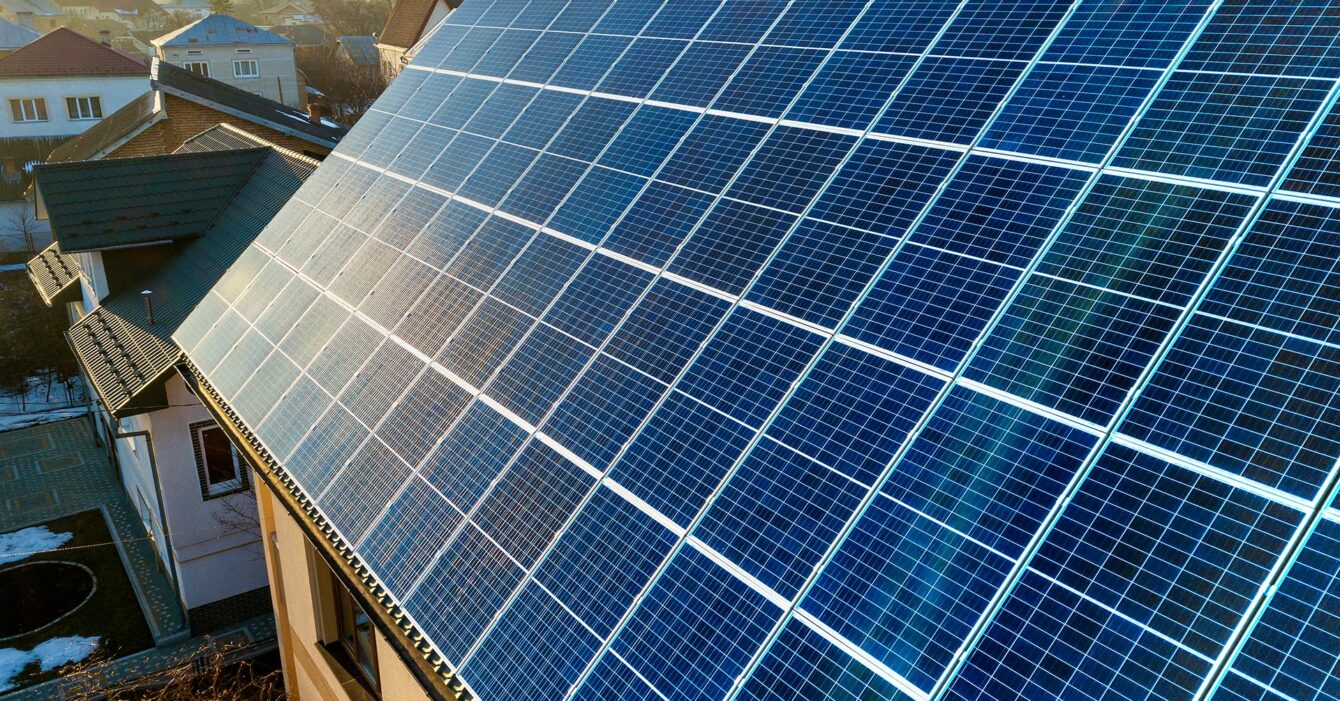 aerial-view-new-modern-two-story-house-cottage-with-blue-shiny-solar-photo-voltaic-panels-system-roof-renewable-ecological-green-energy-production-concept aerial-view-new-modern-two-story-house-cottage-with-blue-shiny-solar-photo-voltaic-panels-system-roof-renewable-ecological-green-energy-production-concept