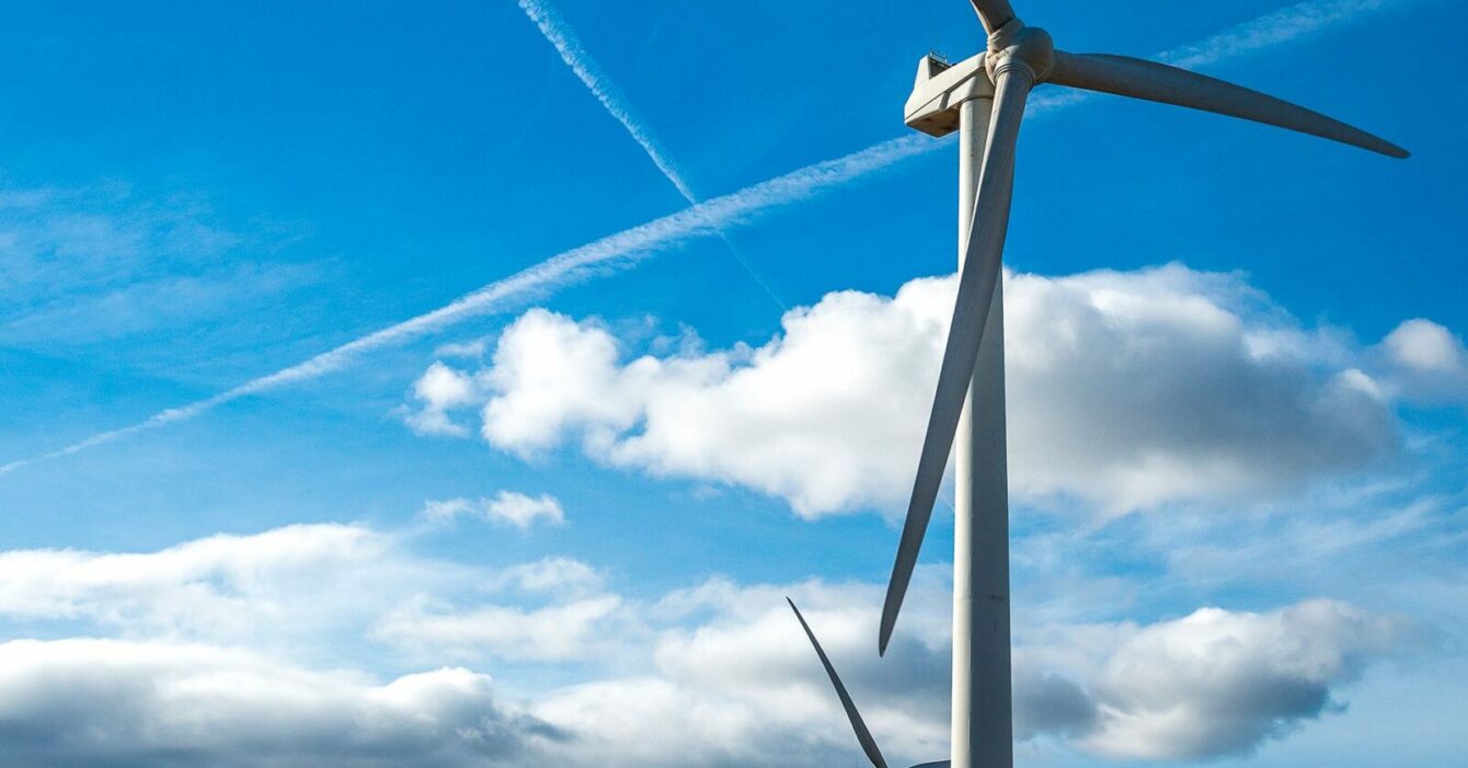 vertical-shot-several-white-electric-windmills-hill-scaled